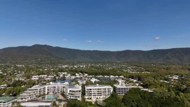Cairns, Queensland 'daki Trinity Plajı, bu 4K hava aracı görüntülerinde, palmiye ağaçları, Taylor Point burnu, sahil tatil beldeleri ve Mercan Denizi' nin turkuaz sularıyla çevrili manzaralı bir plajı göstermektedir. Görüntüler tropikal bölgeleri gösteriyor.