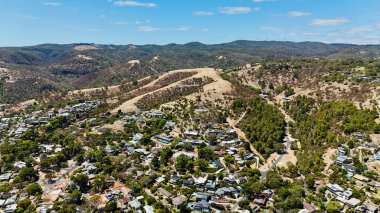 Osmond Dağı, Güney Avustralya 'nın Adelaide Hills şehrinde bulunan ve yüksek görüş noktaları, virajlı yolları ve orman manzarasıyla tanınan güzel bir banliyö. Bu hava aracı görüntüsü yerli çalılıkları, geniş vadileri ve yuva yapmış yamaçlardaki evleri yakalar.