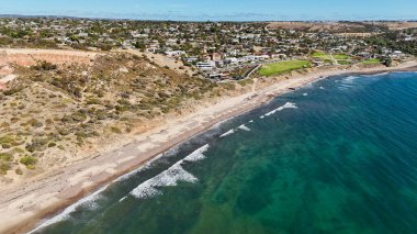 Güney Adelaide, Güney Avustralya 'daki Hallett Cove Sahili çarpıcı jeolojik oluşumları ve antik buzul tarihi ile ünlüdür. Bu hava görüntüsü, yontulmuş kırmızı uçurumları, genişleyen kıyı banliyölerini ve yumuşak eğriyi yakalar.