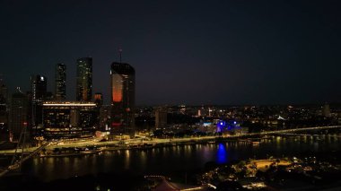 Brisbane CBD 'nin Queensland, Avustralya' daki hava fotoğrafında Brisbane Nehri 'nden yansıyan şehir ışıkları, Brisbane Çarkı, ışıldayan köprüler, gökdelenler ve canlı South Bank bölgesi yer alıyor. Brisbane 'in büyüleyici manzarası
