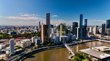Queensland, Avustralya 'daki Brisbane CBD' nin hava görüntüsü modern silueti, Brisbane Nehri ve çevre kentsel manzarayı gözler önüne seriyor. Yüksek binalar, köprüler ve nehir kenarındaki gelişmelerle fotoğraf, bir tanesinin dinamik enerjisini yakalıyor.