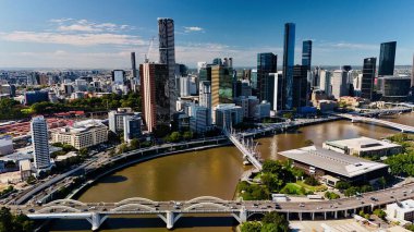 Queensland, Avustralya 'daki Brisbane CBD' nin hava görüntüsü modern silueti, Brisbane Nehri ve çevre kentsel manzarayı gözler önüne seriyor. Yüksek binalar, köprüler ve nehir kenarındaki gelişmelerle fotoğraf, bir tanesinin dinamik enerjisini yakalıyor.