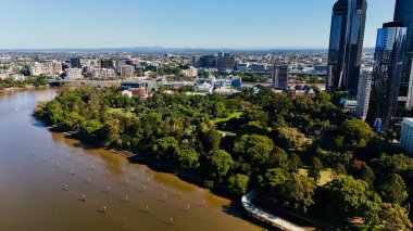 Queensland, Avustralya 'daki Brisbane CBD' nin hava görüntüsü modern silueti, Brisbane Nehri ve çevre kentsel manzarayı gözler önüne seriyor. Yüksek binalar, köprüler ve nehir kenarındaki gelişmelerle fotoğraf, bir tanesinin dinamik enerjisini yakalıyor.