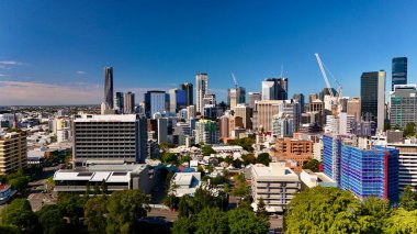 Queensland, Avustralya 'daki Brisbane CBD' nin hava görüntüsü modern silueti, Brisbane Nehri ve çevre kentsel manzarayı gözler önüne seriyor. Yüksek binalar, köprüler ve nehir kenarındaki gelişmelerle fotoğraf, bir tanesinin dinamik enerjisini yakalıyor.