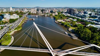 Queensland, Avustralya 'daki Brisbane CBD' nin hava görüntüsü modern silueti, Brisbane Nehri ve çevre kentsel manzarayı gözler önüne seriyor. Yüksek binalar, köprüler ve nehir kenarındaki gelişmelerle fotoğraf, bir tanesinin dinamik enerjisini yakalıyor.