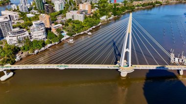 Queensland, Avustralya 'daki Brisbane CBD' nin hava görüntüsü modern silueti, Brisbane Nehri ve çevre kentsel manzarayı gözler önüne seriyor. Yüksek binalar, köprüler ve nehir kenarındaki gelişmelerle fotoğraf, bir tanesinin dinamik enerjisini yakalıyor.