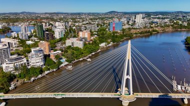 Queensland, Avustralya 'daki Brisbane CBD' nin hava görüntüsü modern silueti, Brisbane Nehri ve çevre kentsel manzarayı gözler önüne seriyor. Yüksek binalar, köprüler ve nehir kenarındaki gelişmelerle fotoğraf, bir tanesinin dinamik enerjisini yakalıyor.