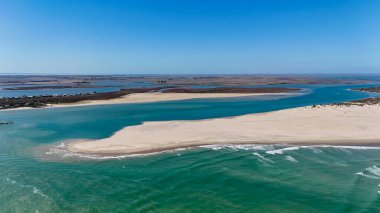 Güney Avustralya 'daki Coorong Ulusal Parkı engin lagün sistemi, kum tepeleri ve el değmemiş doğal güzelliği ile tanınan bir kıyı arazisidir. Bu hava aracı görüntüsü, turkuaz sular ve dolambaçlı estuarin arasındaki çarpıcı kontrastı yakalar.