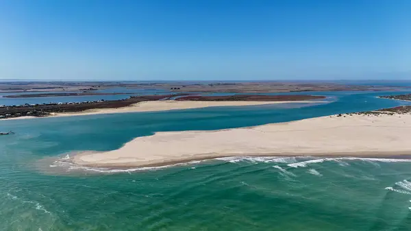 Coorong National Park in South Australia is a coastal wilderness renowned for its vast lagoon system, sand dunes, and pristine natural beauty. This aerial drone footage captures the striking contrast between turquoise waters, winding estuarine