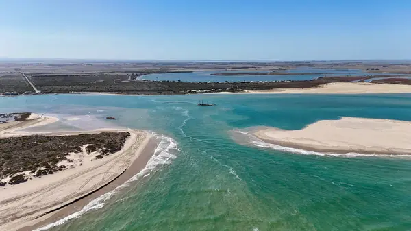 Coorong National Park in South Australia is a coastal wilderness renowned for its vast lagoon system, sand dunes, and pristine natural beauty. This aerial drone footage captures the striking contrast between turquoise waters, winding estuarine