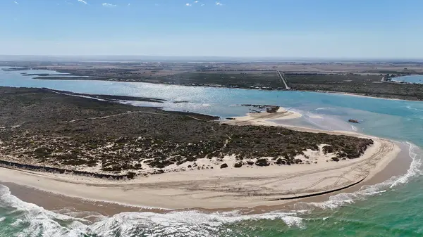 Coorong National Park in South Australia is a coastal wilderness renowned for its vast lagoon system, sand dunes, and pristine natural beauty. This aerial drone footage captures the striking contrast between turquoise waters, winding estuarine