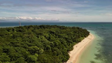 Green Island 'ın hava görüntüleri. Queensland, Avustralya açıklarındaki Büyük Set Resifi' ndeki bir mercan mağarası. Sahne turkuaz suları, uçan resifler, beyaz kumsallar, uzun bir iskele ve iskeleyi ve yoğun tropikal yağmur ormanlarını yakalıyor. Popüler.