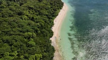 Green Island 'ın hava görüntüleri. Queensland, Avustralya açıklarındaki Büyük Set Resifi' ndeki bir mercan mağarası. Sahne turkuaz suları, uçan resifler, beyaz kumsallar, uzun bir iskele ve iskeleyi ve yoğun tropikal yağmur ormanlarını yakalıyor. Popüler.