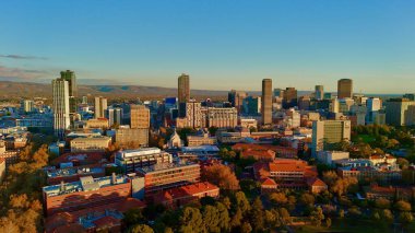 Adelaide CBD 'nin Güney Avustralya' daki hava batımı görüntüsü, şehrin modern gökdelenlerini, yüksek gökdelenleri ve yeşil parklarla çevrili Adelaide Üniversitesi kampüsünü gösteriyor. Görüntü, şehir manzarasını sıcak altın saatinde yakalıyor.