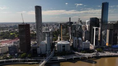 Queensland, Avustralya 'daki Brisbane CBD' nin 4K hava aracı görüntüleri modern şehir silueti, yüksek gökdelenler ve dolambaçlı Brisbane Nehri 'ni gösteriyor. Simgesel köprüleri, şehir altyapısını, South Bank parklarını ve canlı sahil kenarlarını yakalıyor.