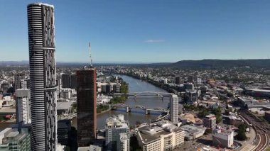 Queensland, Avustralya 'daki Brisbane CBD' nin 4K hava aracı görüntüleri modern şehir silueti, yüksek gökdelenler ve dolambaçlı Brisbane Nehri 'ni gösteriyor. Simgesel köprüleri, şehir altyapısını, South Bank parklarını ve canlı sahil kenarlarını yakalıyor.