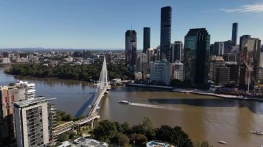 Queensland, Avustralya 'daki Brisbane CBD' nin 4K hava aracı görüntüleri modern şehir silueti, yüksek gökdelenler ve dolambaçlı Brisbane Nehri 'ni gösteriyor. Simgesel köprüleri, şehir altyapısını, South Bank parklarını ve canlı sahil kenarlarını yakalıyor.
