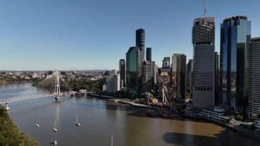 Queensland, Avustralya 'daki Brisbane CBD' nin 4K hava aracı görüntüleri modern şehir silueti, yüksek gökdelenler ve dolambaçlı Brisbane Nehri 'ni gösteriyor. Simgesel köprüleri, şehir altyapısını, South Bank parklarını ve canlı sahil kenarlarını yakalıyor.
