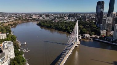 Queensland, Avustralya 'daki Brisbane CBD' nin 4K hava aracı görüntüleri modern şehir silueti, yüksek gökdelenler ve dolambaçlı Brisbane Nehri 'ni gösteriyor. Simgesel köprüleri, şehir altyapısını, South Bank parklarını ve canlı sahil kenarlarını yakalıyor.