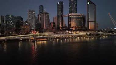 Queensland, Avustralya 'daki Brisbane CBD' nin 4K hava aracı görüntüleri, aydınlık gökdelenler, canlı şehir ışıkları ve köprüler boyunca akan trafik akışlarını gösteriyor. Görüntüler, Brisbane 'in ikonik Çarkıfeleği' ni yakalıyor. Güney Şeria 'nın manzaralı bölgesi.