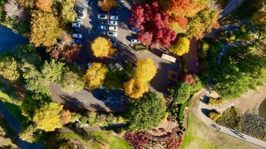 Bu hava aracı görüntüsü Güney Avustralya Adelaide Hills 'teki Lofty Dağı Botanik Bahçesi' nin canlı sonbahar güzelliğini yakalar. Bahçe kırmızı, turuncu ve altın renkleri ile patlar, dolambaçlı yürüyüş yolları arasında geçer, sakin göller ve orman