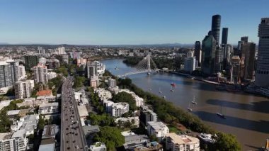 Queensland, Avustralya 'daki Brisbane CBD' nin 4K hava aracı görüntüleri modern şehir silueti, yüksek gökdelenler ve dolambaçlı Brisbane Nehri 'ni gösteriyor. Simgesel köprüleri, şehir altyapısını, South Bank parklarını ve canlı sahil kenarlarını yakalıyor.