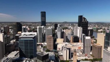 Queensland, Avustralya 'daki Brisbane CBD' nin 4K hava aracı görüntüleri modern şehir silueti, yüksek gökdelenler ve dolambaçlı Brisbane Nehri 'ni gösteriyor. Simgesel köprüleri, şehir altyapısını, South Bank parklarını ve canlı sahil kenarlarını yakalıyor.