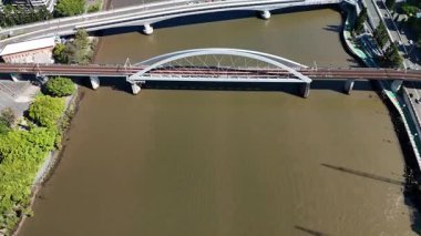 Queensland, Avustralya 'daki Brisbane CBD' nin 4K hava aracı görüntüleri modern şehir silueti, yüksek gökdelenler ve dolambaçlı Brisbane Nehri 'ni gösteriyor. Simgesel köprüleri, şehir altyapısını, South Bank parklarını ve canlı sahil kenarlarını yakalıyor.