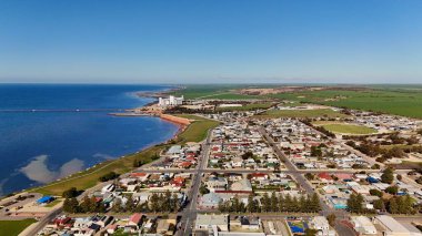 Güney Avustralya 'daki Yorke Yarımadası' nda yer alan Ardrossan, yüksek kızıl kıyı kayalıkları, tarihi iskelesi ve büyüleyici deniz kenti atmosferiyle ünlüdür. Bu 4K hava aracı engebeli kıyı şeridinin nefes kesici görüntülerini kaydediyor.