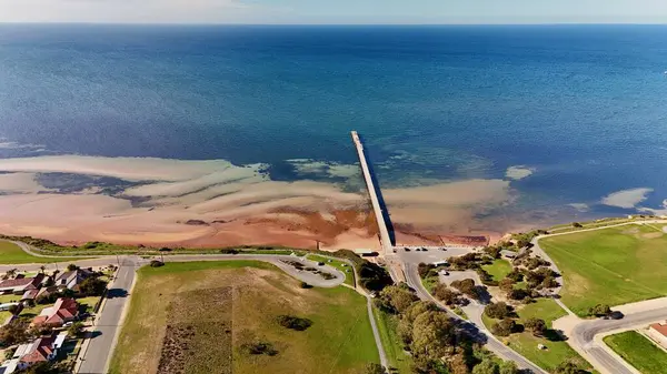 Güney Avustralya 'daki Yorke Yarımadası' nda yer alan Ardrossan, yüksek kızıl kıyı kayalıkları, tarihi iskelesi ve büyüleyici deniz kenti atmosferiyle ünlüdür. Bu 4K hava aracı engebeli kıyı şeridinin nefes kesici görüntülerini kaydediyor.