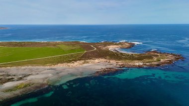 Bu görüntü, mavi okyanusun arka planına karşı engebeli bir sahil şeridinde duran tarihi Corny Point Deniz fenerini yakalar. 1882 'de inşa edilen deniz feneri, Spencer Körfezi boyunca gemilere yol gösteren simgesel bir deniz simgesi olmaya devam ediyor. Sahne gösteriyor ki