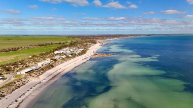Bu hava görüntülerinde Hardwicke Körfezi 'nin beyaz kumlu sahilleri, turkuaz suları ve çevresindeki tarım arazileri yer alıyor. Video, sakin bölge ile yeşil kırsal bölge arasındaki zıtlığı vurguluyor.