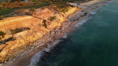Güney Avustralya 'daki Port Willunga Sahili altın kireçtaşı uçurumları, turkuaz suları ve tarihi iskelesinden arta kalanlarla çarpıcı bir kıyı manzarası sunuyor. Yukarıdan çekilen bu drone görüntüleri dramatik kıyı şeridini vurguluyor, yumuşak kumlu plajı.