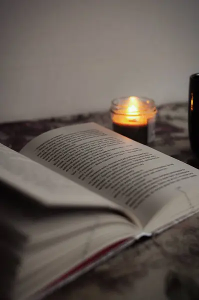 Sıcak bir akşam: bir kitap ve bir mum samimi bir atmosfer yaratır