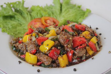 Renkli Bell Peppers, Soğan ve Marul Garnitürlü Lezzetli Kara Biber Bifteği