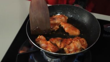 Ahşap Spatula Yakın Çekim Mutfak Sahnesi ile Kızartma Tavasında marine edilmiş Tavuk