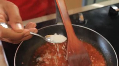 Bir insan tabağa şeker ekler.