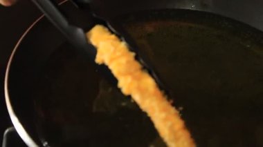 Birisi tavuk katsu kızartıyor. Tavuk katsu yemeği.