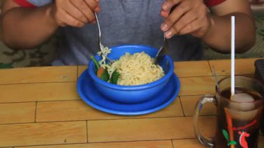 Bir kase kızarmış erişte. Birileri bir kase erişte yiyor.