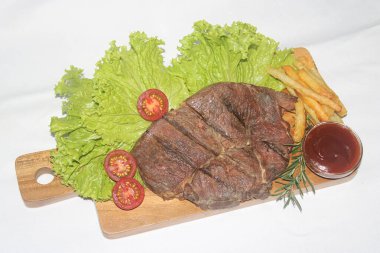 Marul, domates ve soslu leziz ızgara et tabağı.