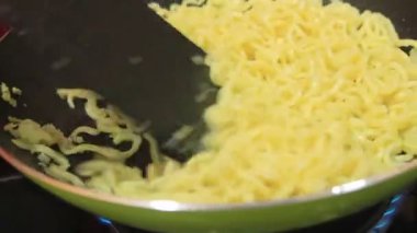 Kızarmış erişte pişiriyorum. İnsanlar tavada erişte pişiriyor.