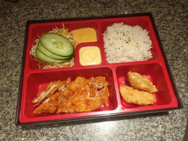 Japon Bento Kutusu, kızarmış tavuk, pilav ve sebzeli granit masa.