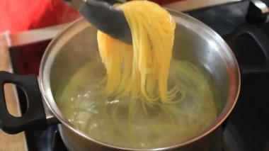 Bir insan pişmiş spagetti süzer. Spagetti pişirmeyi bitirdim.