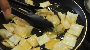 Birisi kızarmış hamur köftesi pişiriyor.