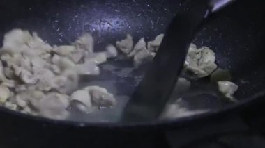 Bir şef tavuk sote ediyor.