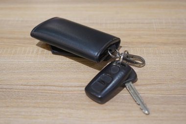 Ahşap Masada Anahtarları olan Siyah Deri Araba Anahtarı