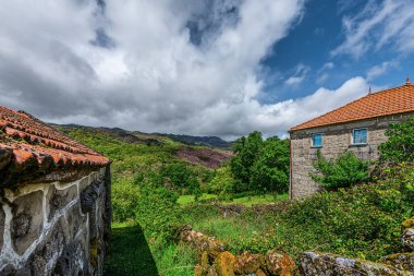 Castro Laboreiro, Portekiz 05-02-2024: Peneda Geres Ulusal Parkı 'nın Viana do Castelo Bölgesi' nde yer alan küçük Castro Laboreiro köyünün hemen dışındaki küçük tarihi evler.
