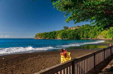 Tahiti 'deki sahil şeridi bilinmeyen bir tatil köyünün önünde siyah bir kumsal gösteriyor.