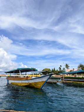 Geleneksel tekne Manokwari 'nin el değmemiş kıyılarına yanaşır berrak mavi gökyüzünün altında, Batı Papuas sahil hayatının dingin güzelliğini ve bozulmamış doğal cazibesini yakalar..