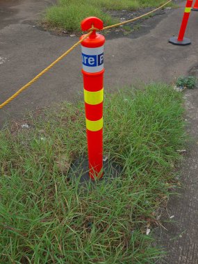 Çimenlerle çevrili yıpranmış güvenli bir park bariyeri. Zamanda güçlü ve dirençli duruyor. Doğanın büyümesini temsil ediyor..